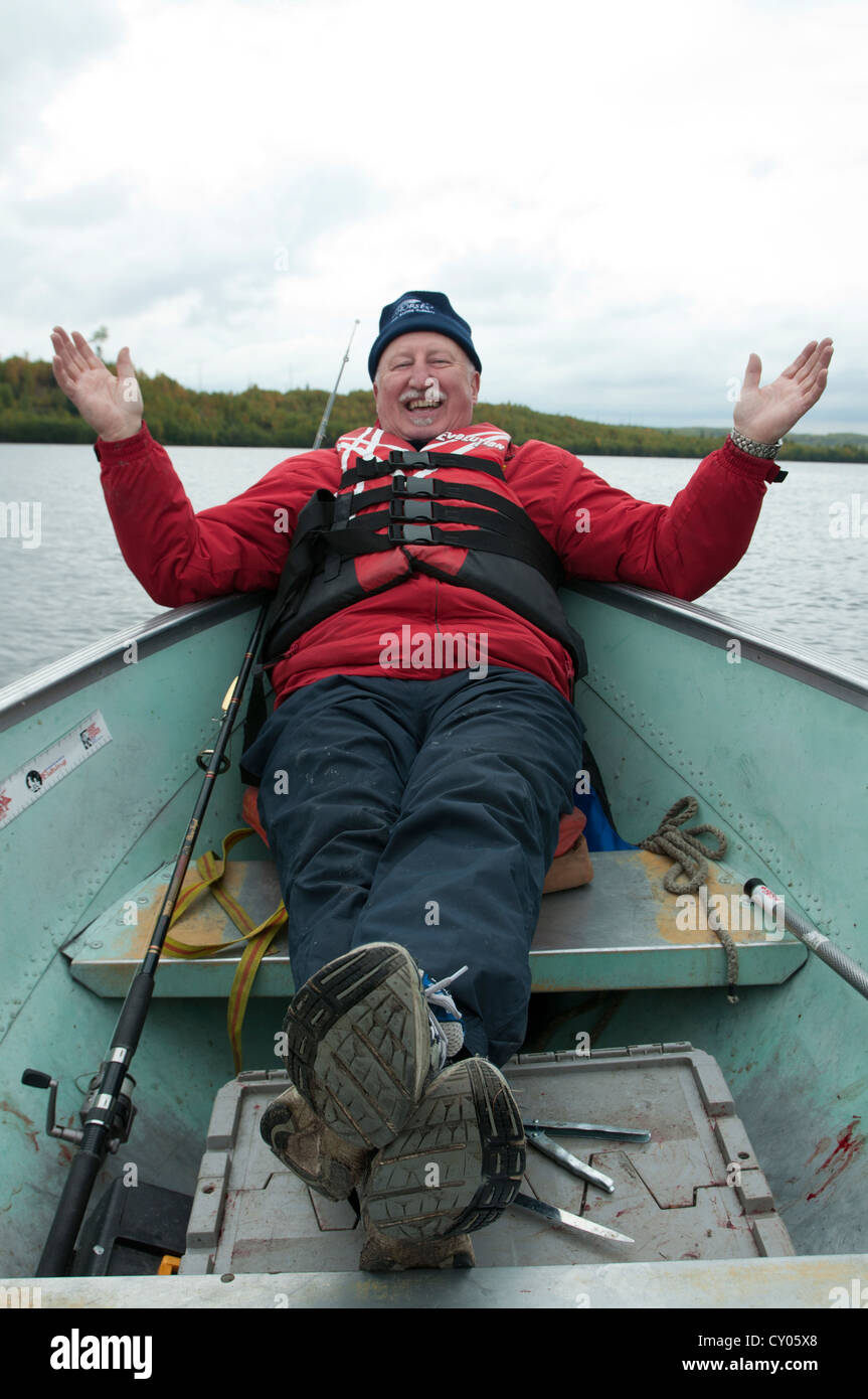 Happy fisherman Don Wilson of Alberta, Canada, shown after releasing a tropht pike on Namur Lake in northern Alberta. Stock Photo