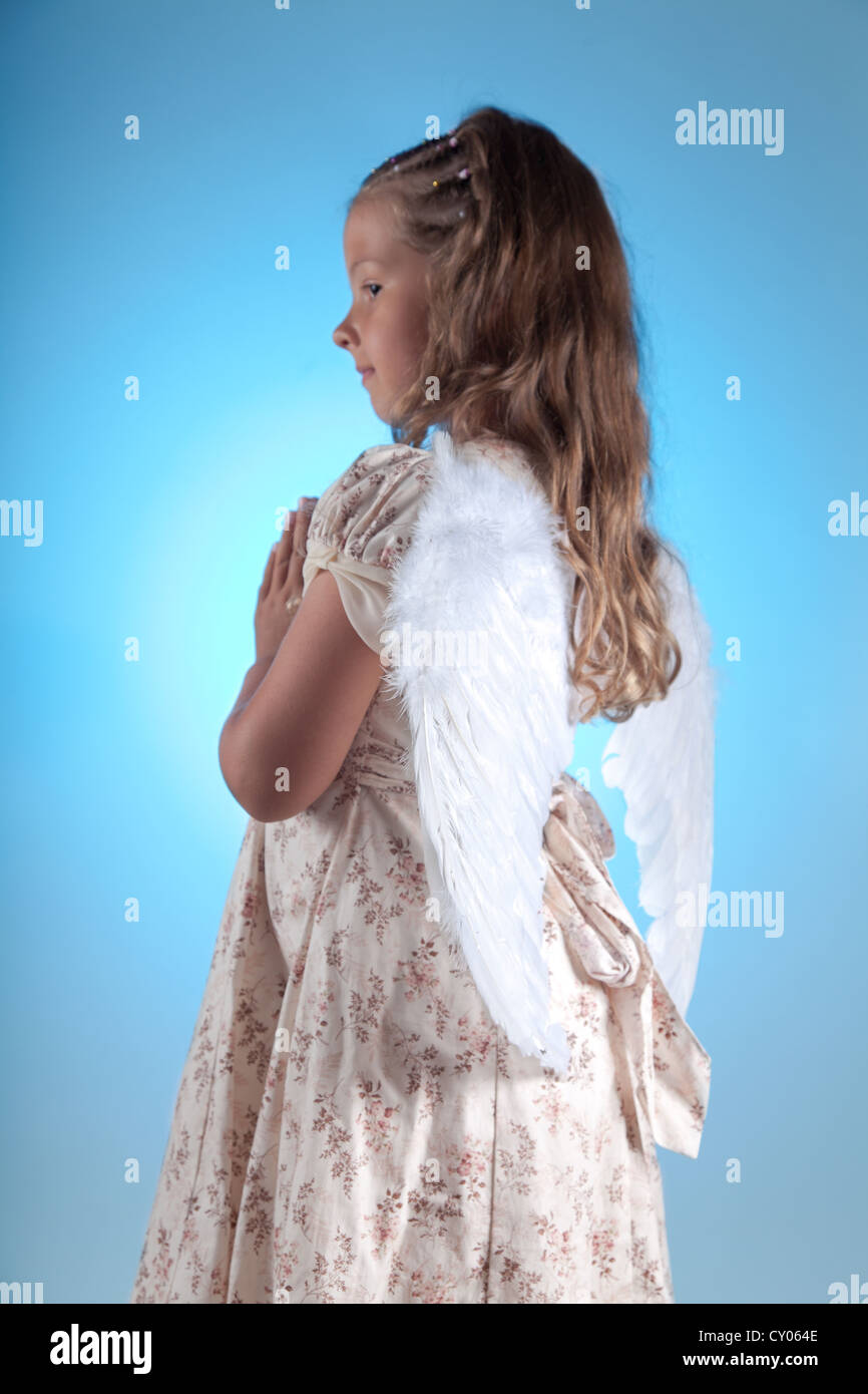 Cute little angel praying, focus on wings Stock Photo