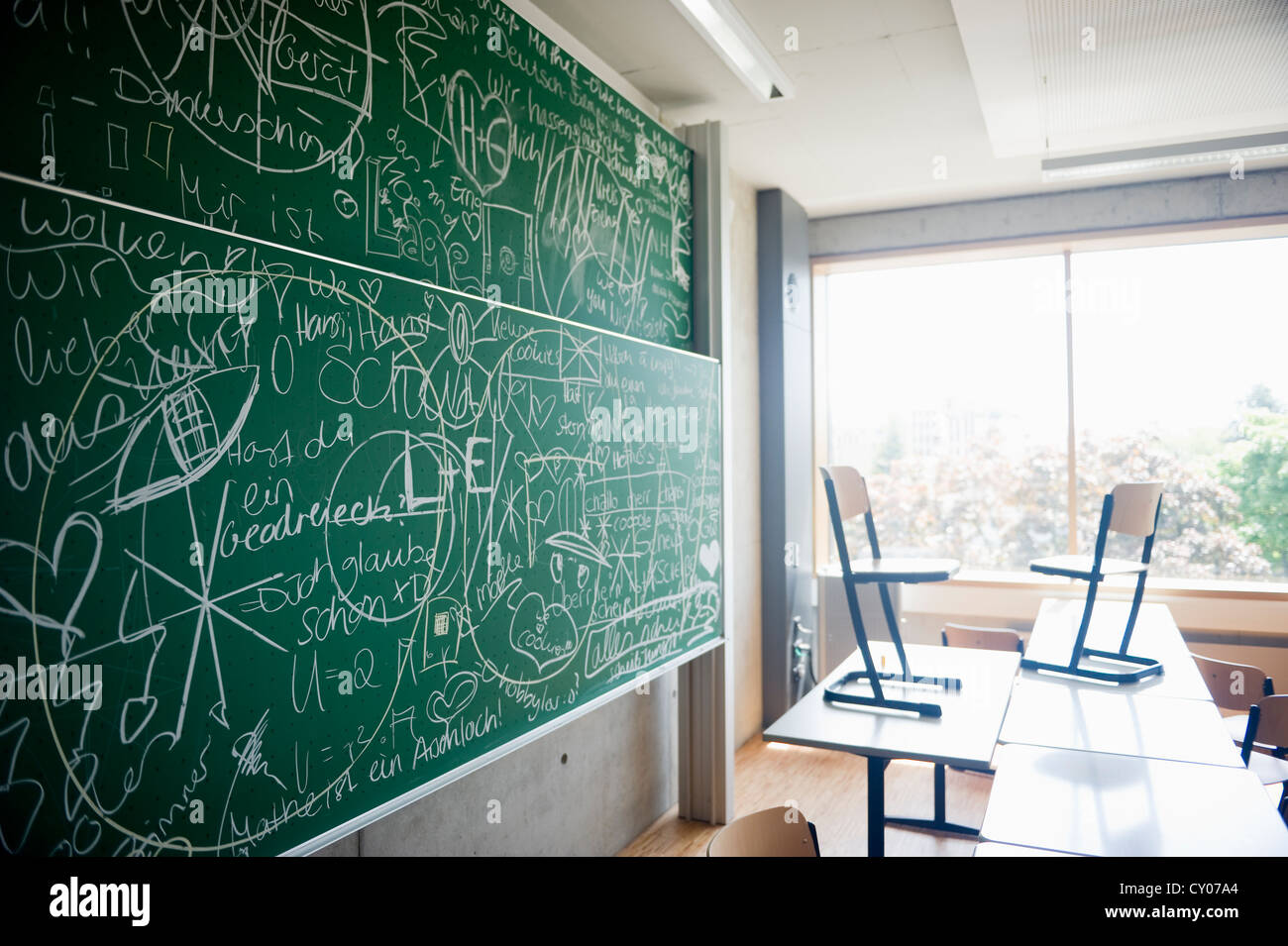 Classroom of a grammar school with a blackboard covered with writing Stock Photo