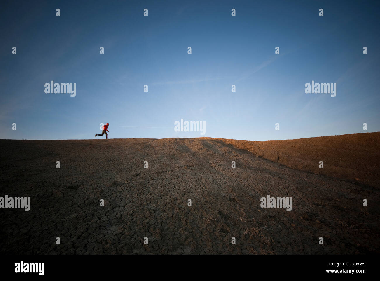 Male figures running in desert Stock Photo