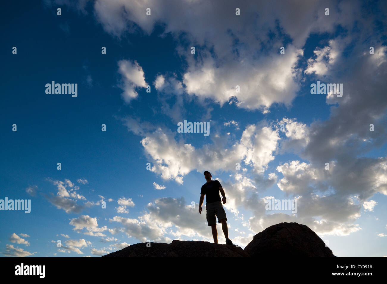 Silhouette of male figure standing on rock Stock Photo
