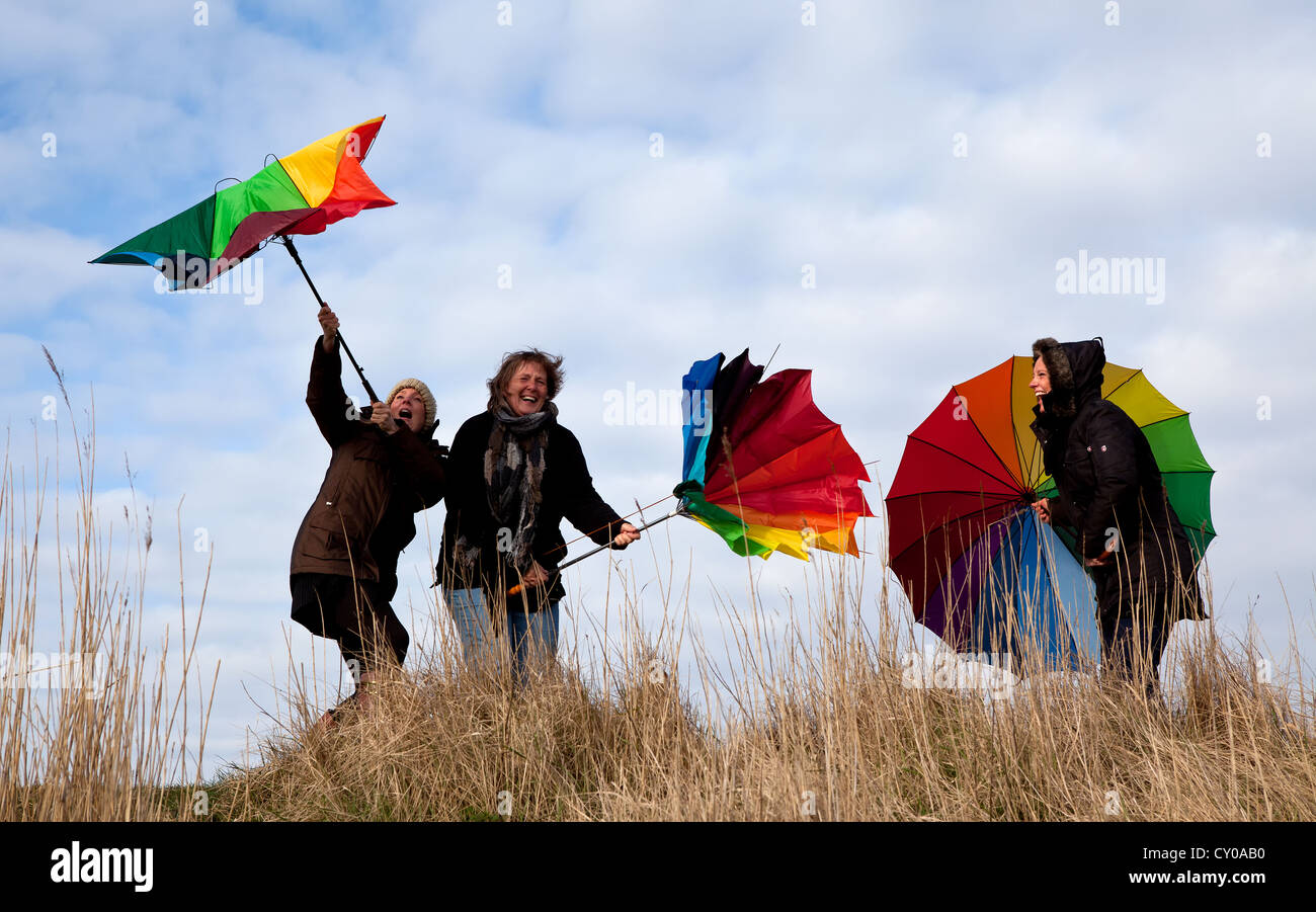 Three women holding umbrellas, stormy weather, Sankt Peter-Ording, Schleswig-Holstein Stock Photo
