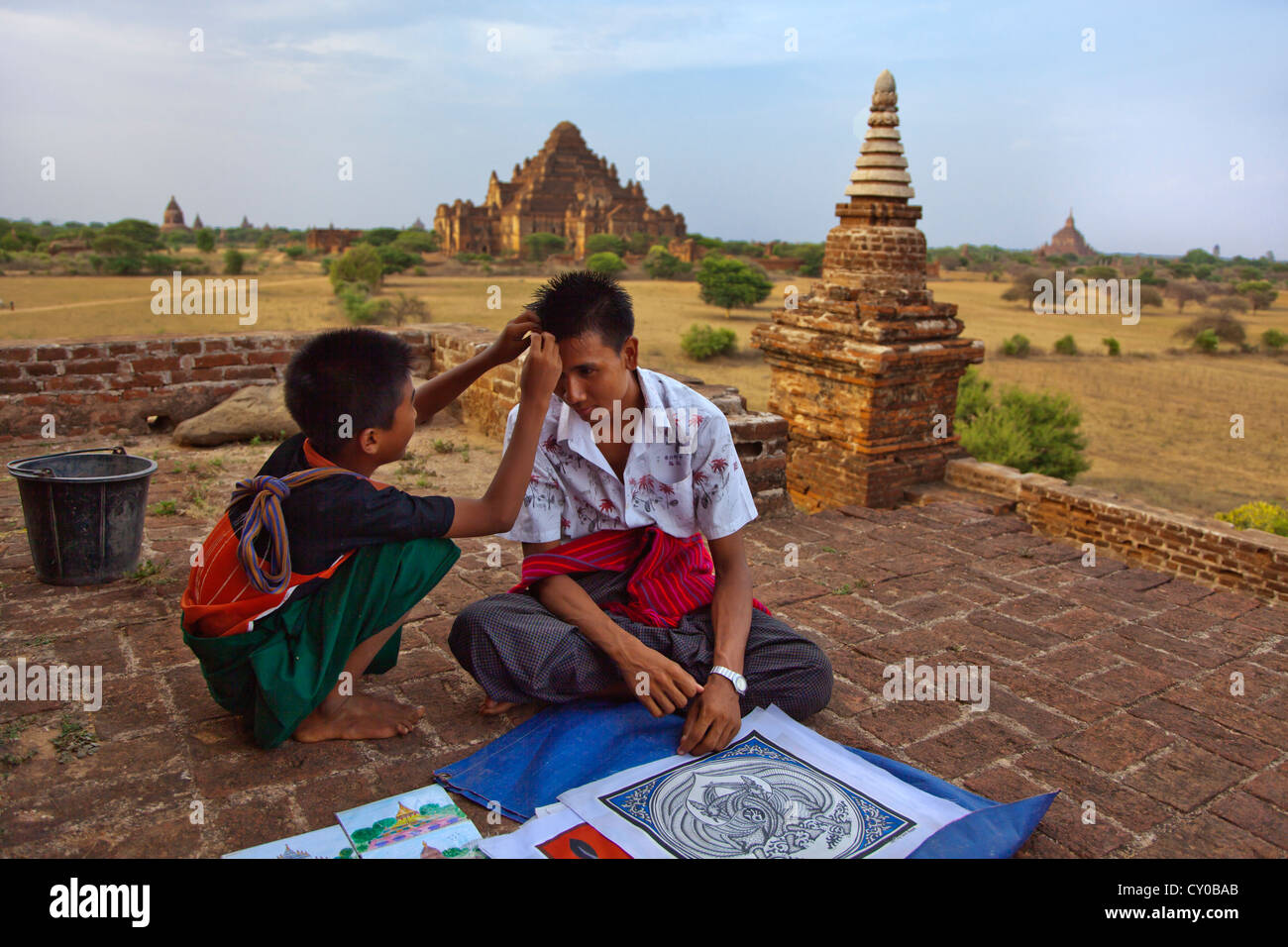 Selling paintings while viewing the 12th century DHAMMAYANGYI PAHTO  in BAGAN built by Narathu - MYANMAR Stock Photo