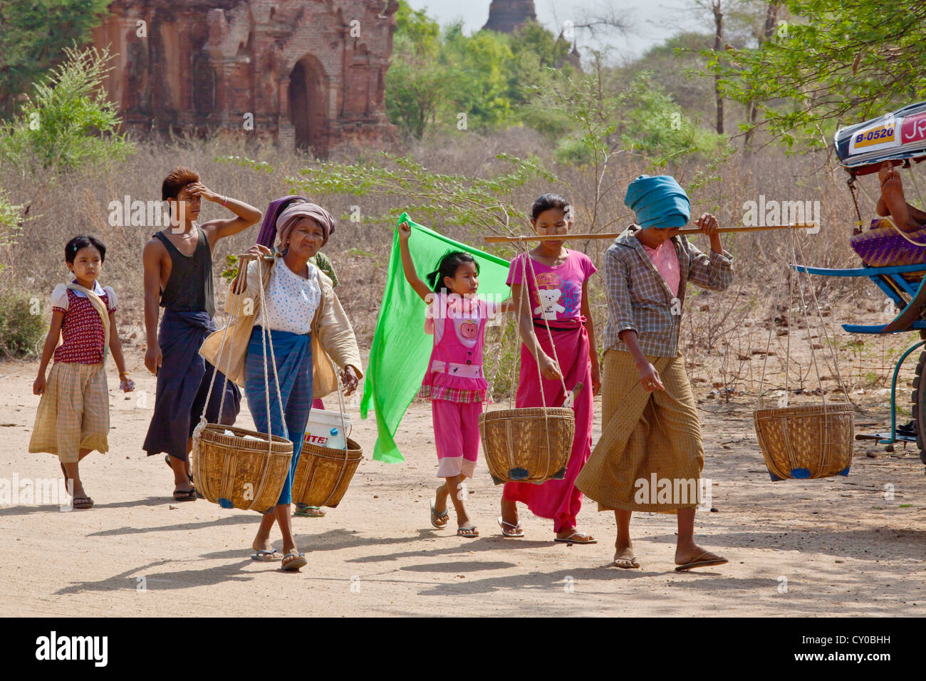 Villagers carry goods to market on the plains of BAGAN - MYANMAR Stock Photo