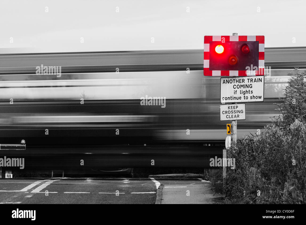 Train passing crossing point on road in England, UK Stock Photo