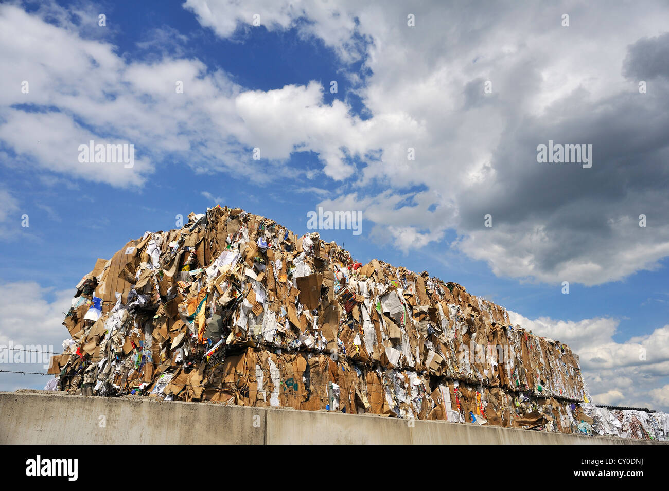 Pressed and stacked waste paper behind the wall of a recycling company ...