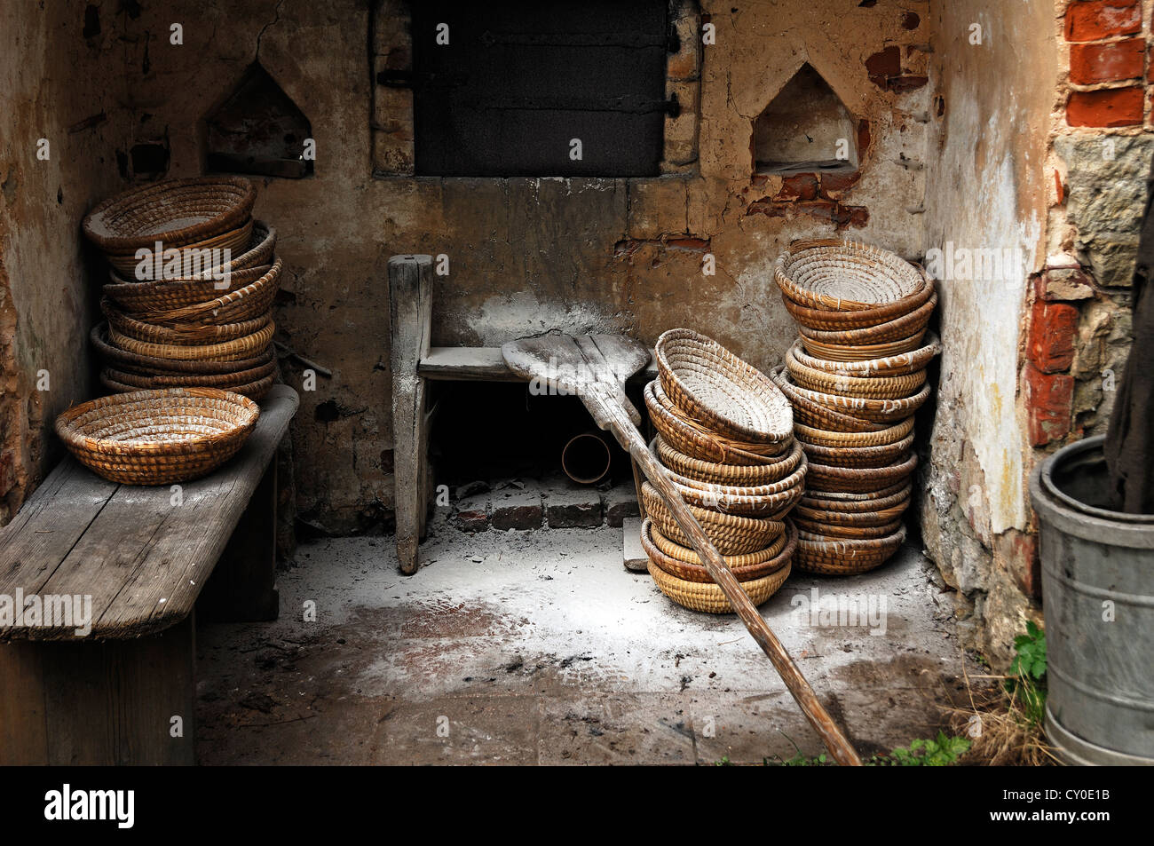 Bread baskets and paddle covered in flour in front of a small building