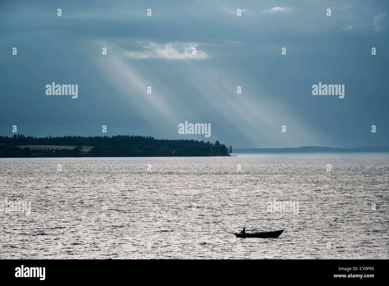 Man in small boat on fishing trip at night Stock Photo