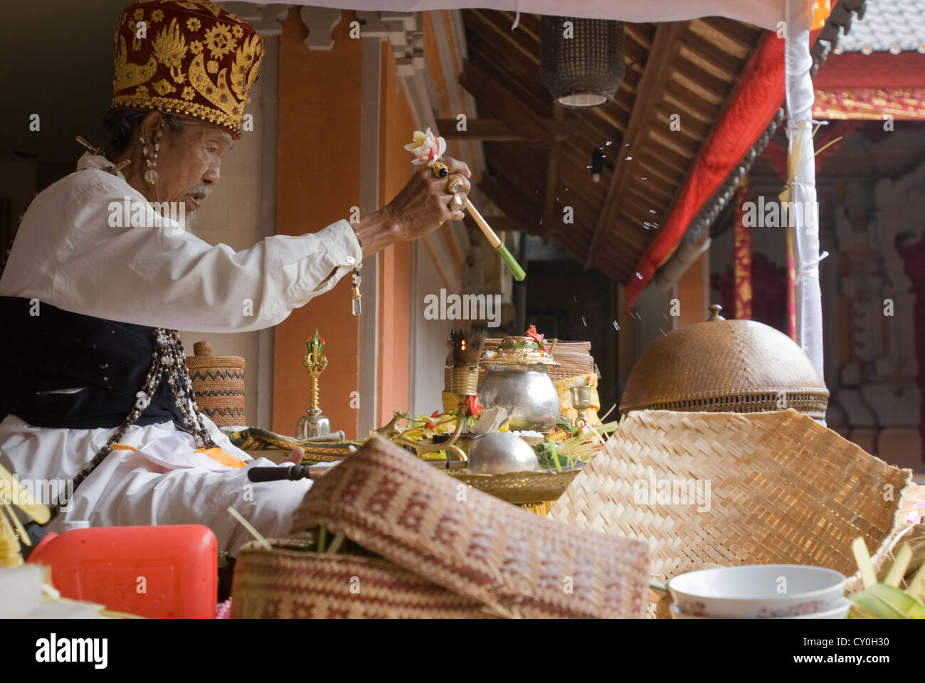 An Animist High Priest performs a protection ritual at a funerary ceremony in Ubud, Bali, Indonesia Stock Photo