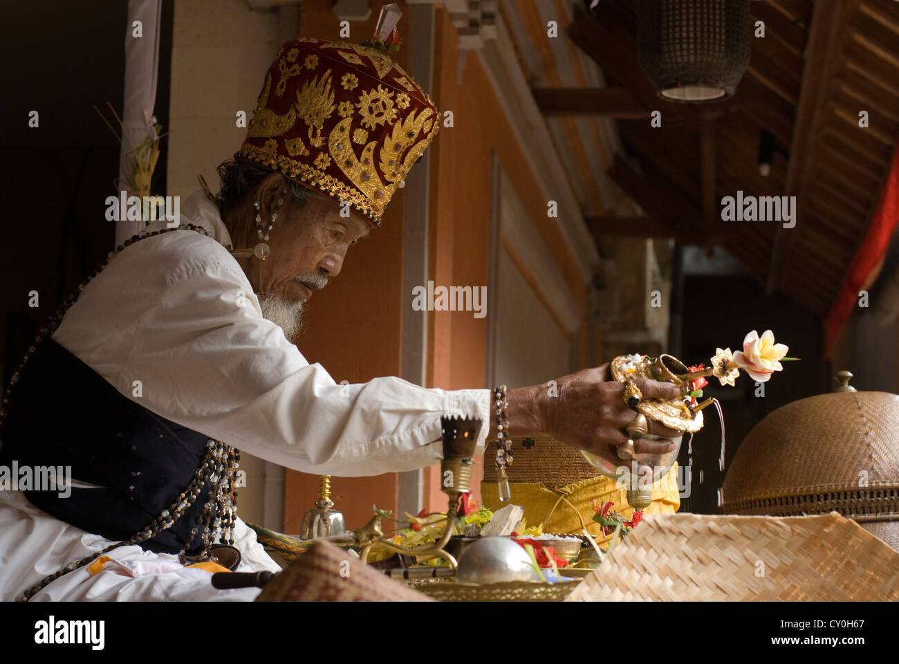 An Animist High Priest performs a protection ritual at a funerary ceremony in Ubud, Bali, Indonesia Stock Photo