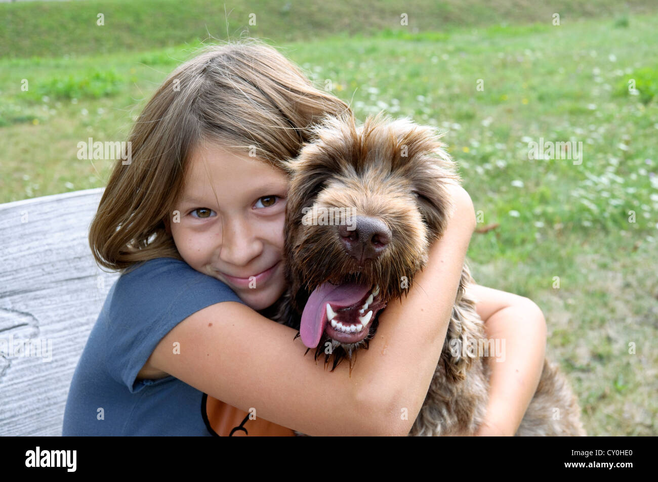 Young girl 10 years old cuddling pet mongrel dog Stock Photo Alamy