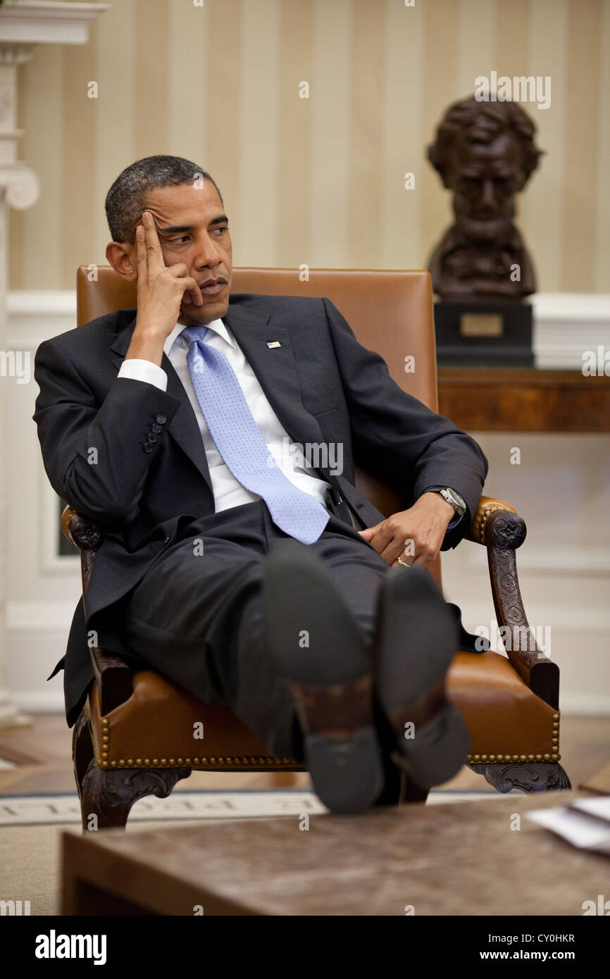 US President Barack Obama listens during a meeting with advisors June 8, 2011 in the Oval Office of the White House. Stock Photo