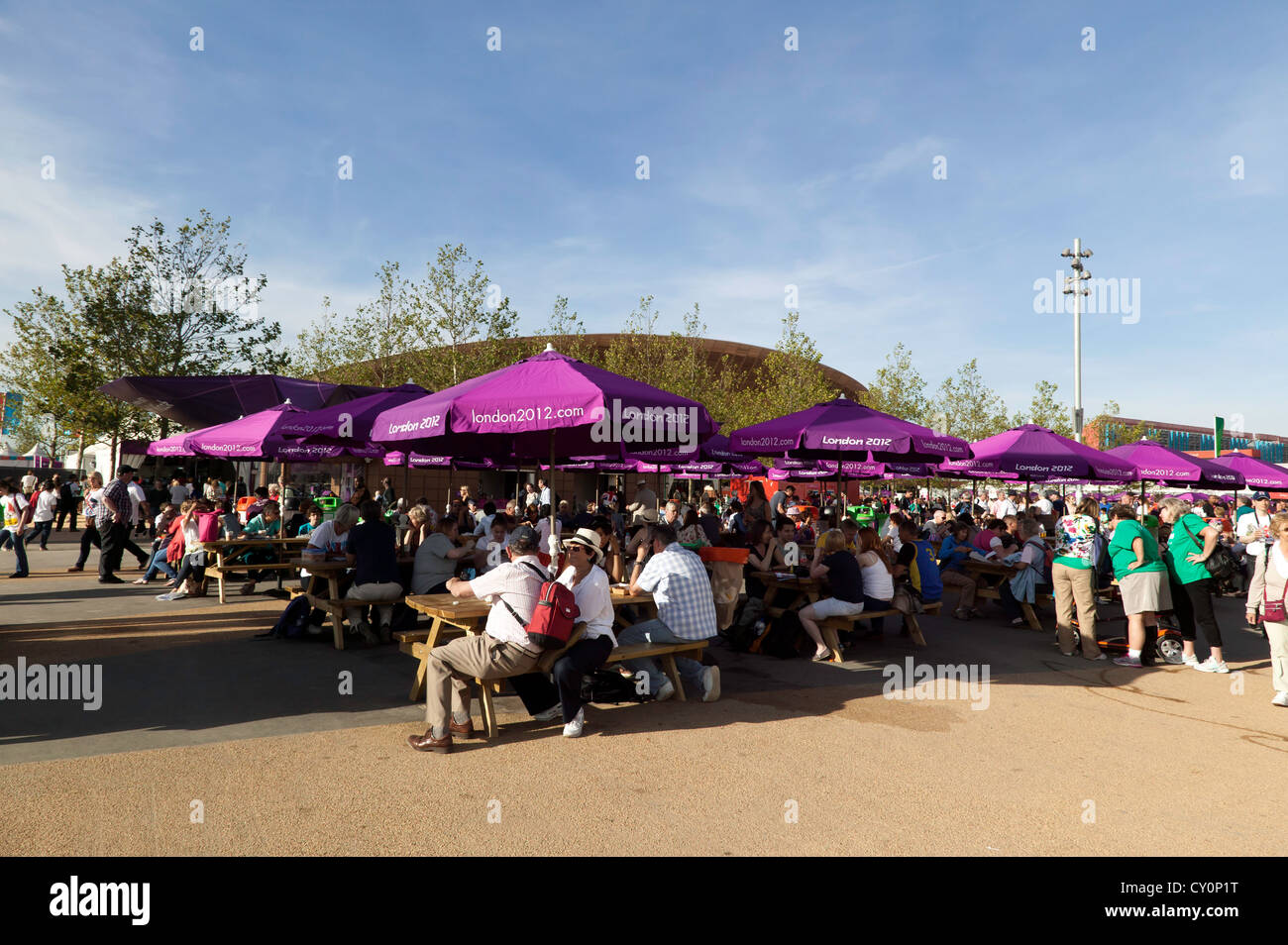 Visitors relaxing and sheltering from the sun under umberellas, in the Olympic Park, Stratford, during the  2012 Summer Paralympic Games Stock Photo