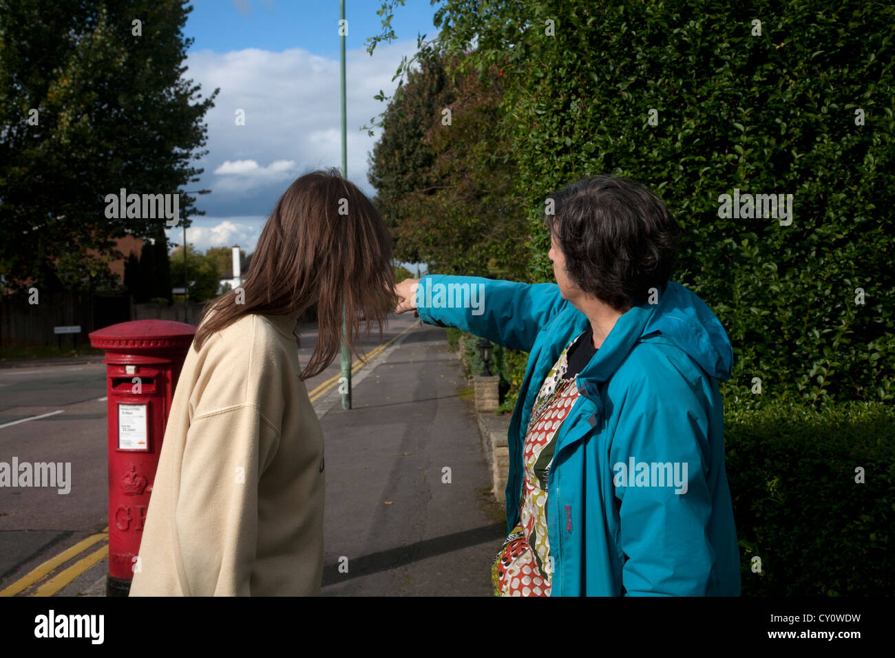 Woman pointing in the street and giving directions to another woman Stock Photo