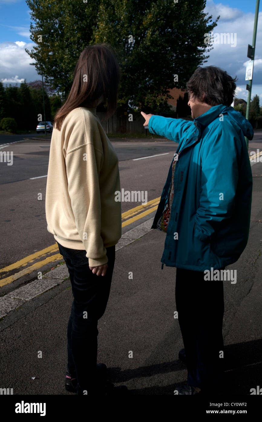 Woman pointing in the street and giving directions to another woman Stock Photo