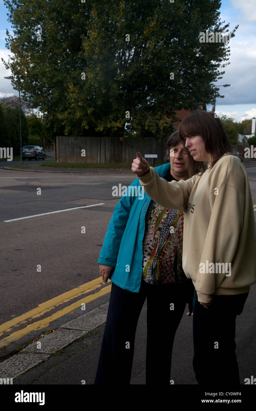 Woman pointing in the street and giving directions to another woman Stock Photo