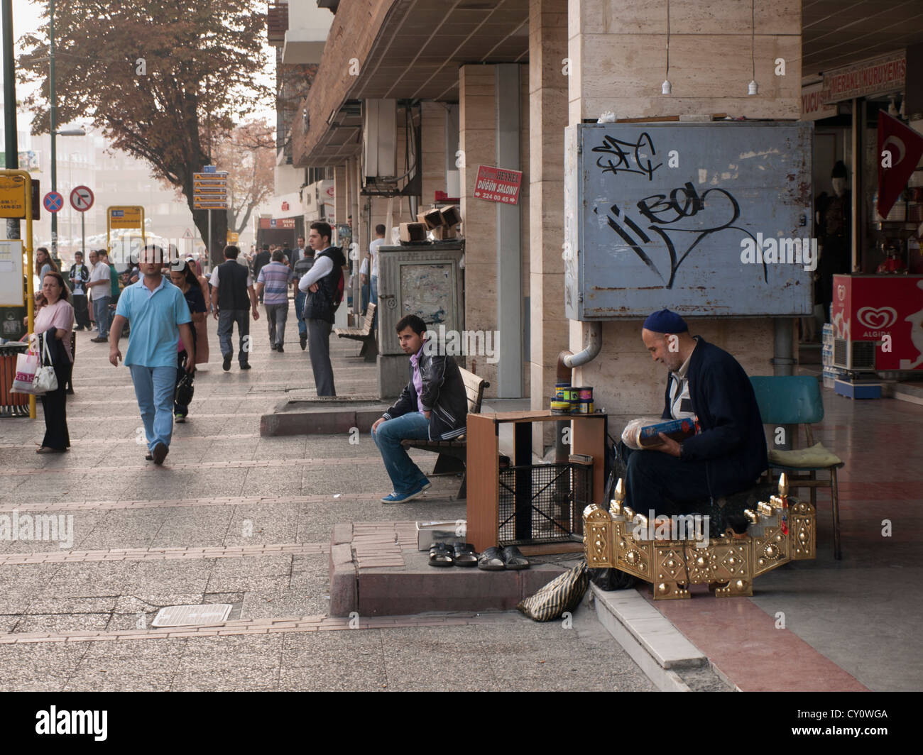 Shoe shine and early morning pedestrian traffic om Atatürk boulevard in Bursa Turkey Stock Photo
