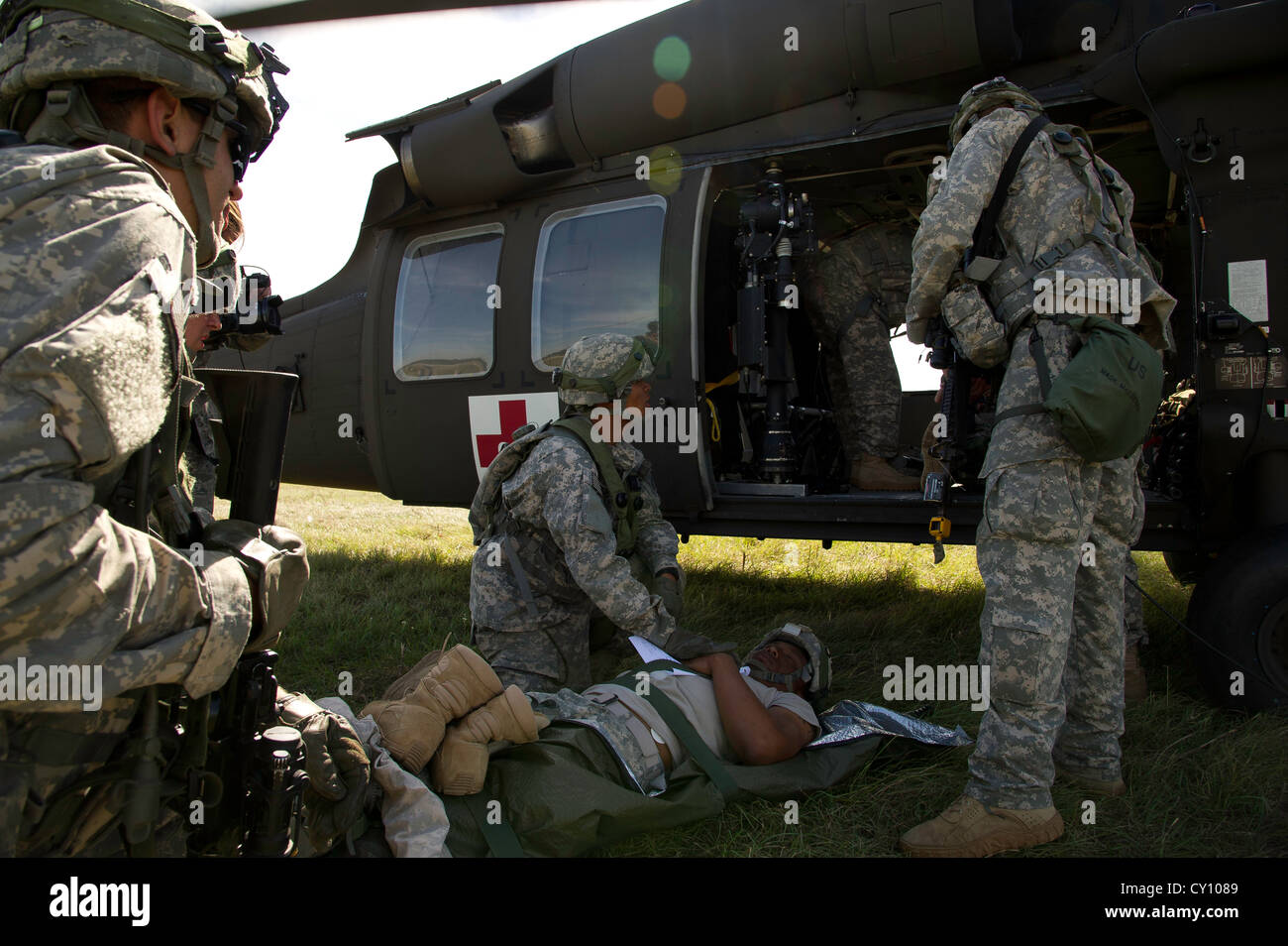 U.S. Army Soldiers prepare to load a simulated patient onto a UH-60M Black Hawk helicopter during a field exercise at the Joint Readiness Training Center (JRTC), Fort Polk, La., Oct. 15, 2012. JRTC 13-01 is designed to prepare and educate U.S. military Service members for deployments to the Middle East. Stock Photo