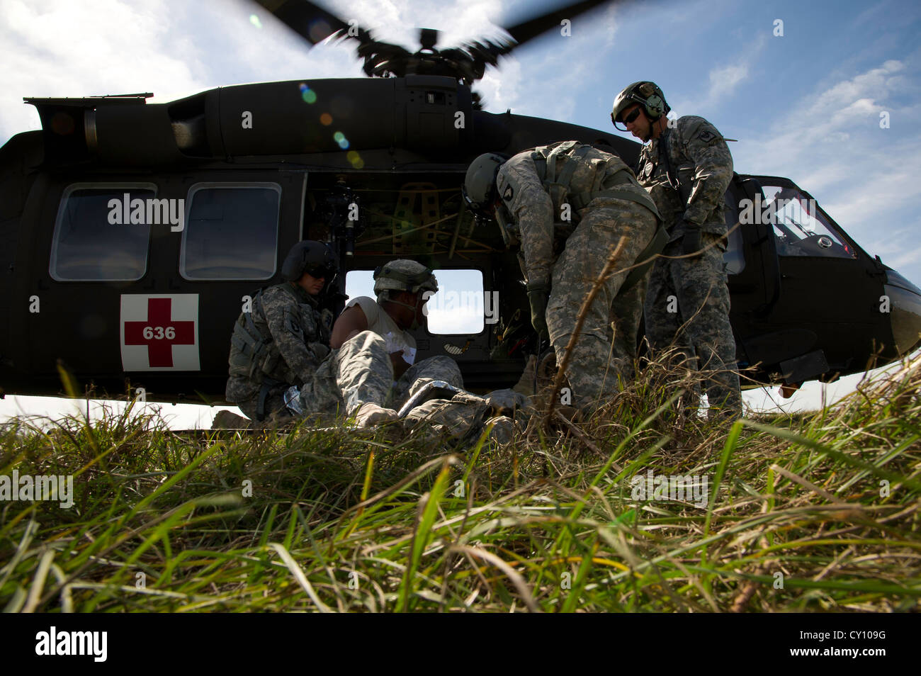 U.S. Army Soldiers prepare to load a simulated patient onto a UH-60M Black Hawk helicopter during a field exercise at the Joint Readiness Training Center (JRTC), Fort Polk, La., Oct. 15, 2012. JRTC 13-01 is designed to prepare and educate U.S. military Service members for deployments to the Middle East. Stock Photo