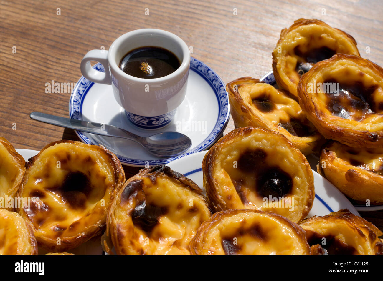 Pasteis de Nata or Pasteis de Belem; custard tarts, on a café table outdoors with a bica coffee; Belém, Lisbon, Portugal Stock Photo
