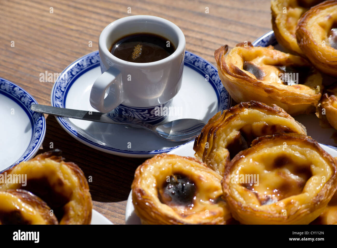 Pasteis de Nata or Pasteis de Belem; custard tarts, on a café table outdoors with bica coffees; Belém, Lisbon, Portugal Stock Photo