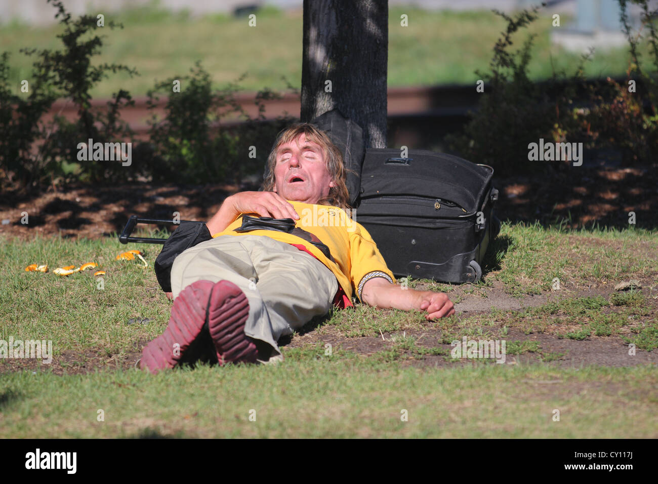 Homeless man sleeping in park Stock Photo