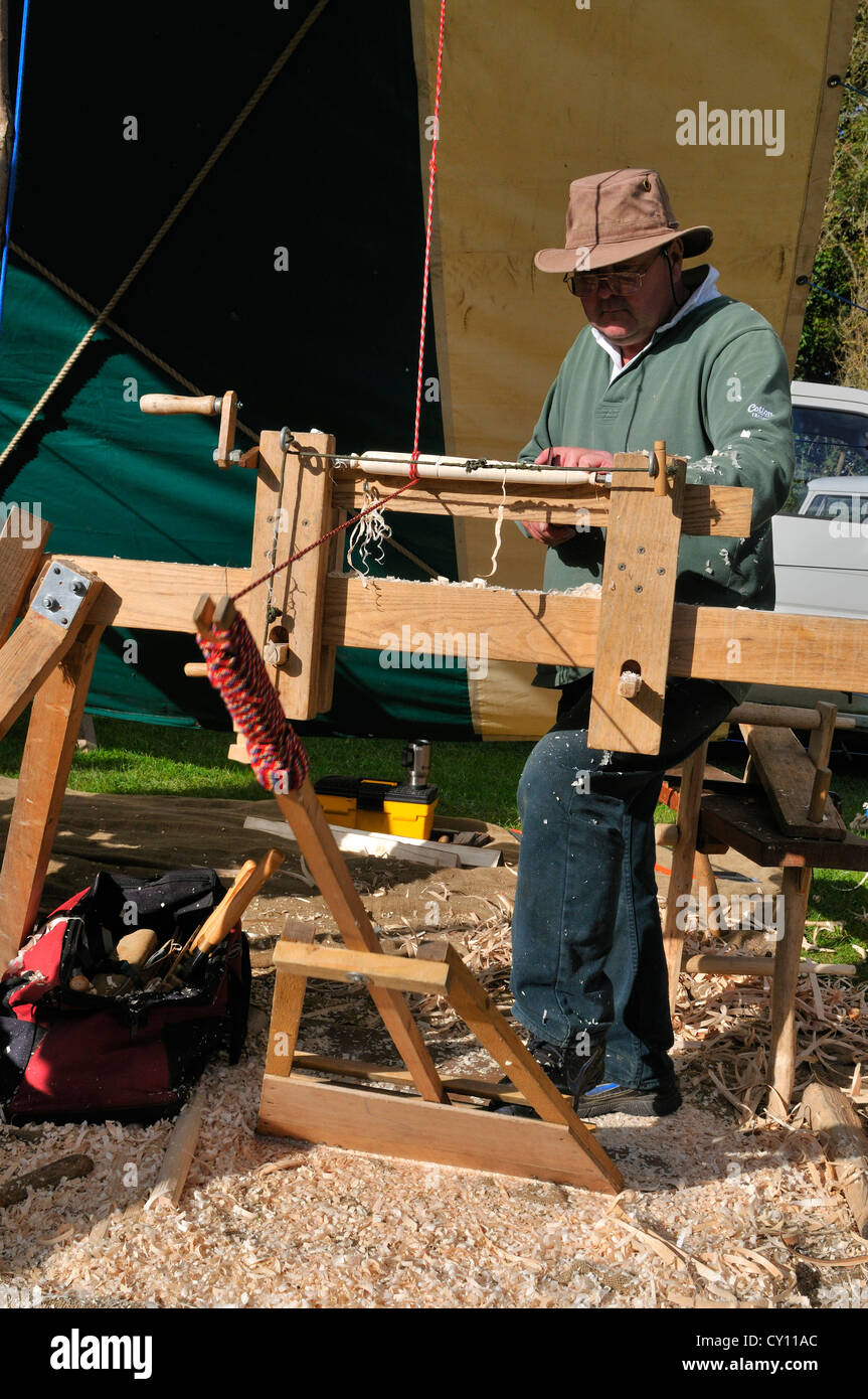Man demonstrating Pole Lathe Turning , on a treadle lathe,  making chair spindles at the Autumn Countryside Show, West Sussex, England, UK Stock Photo