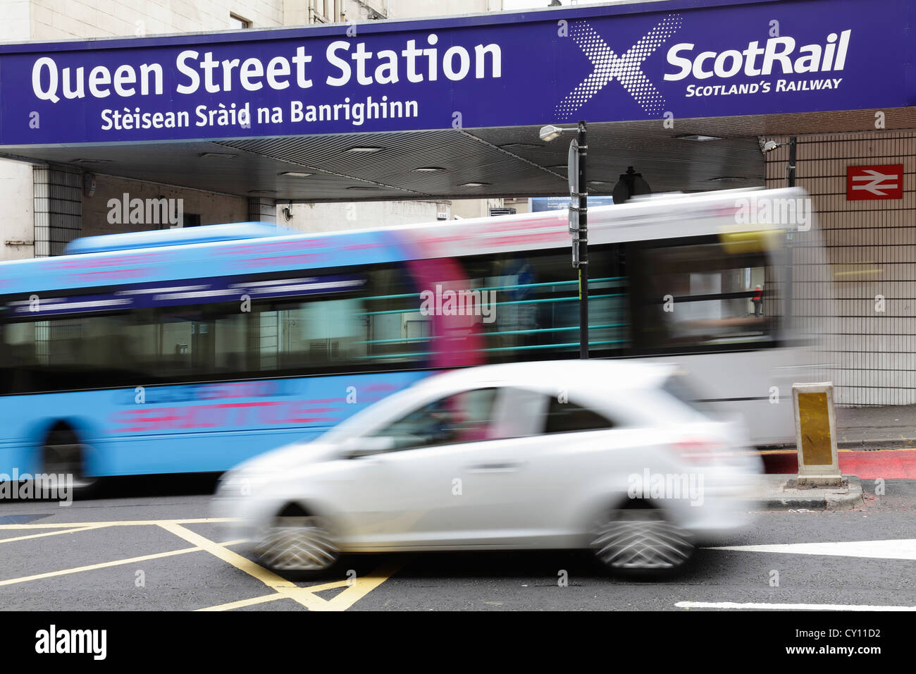 Queen Street Station sign with motion blurred bus and car on North Hanover Street in Glasgow city centre, Scotland, UK Stock Photo