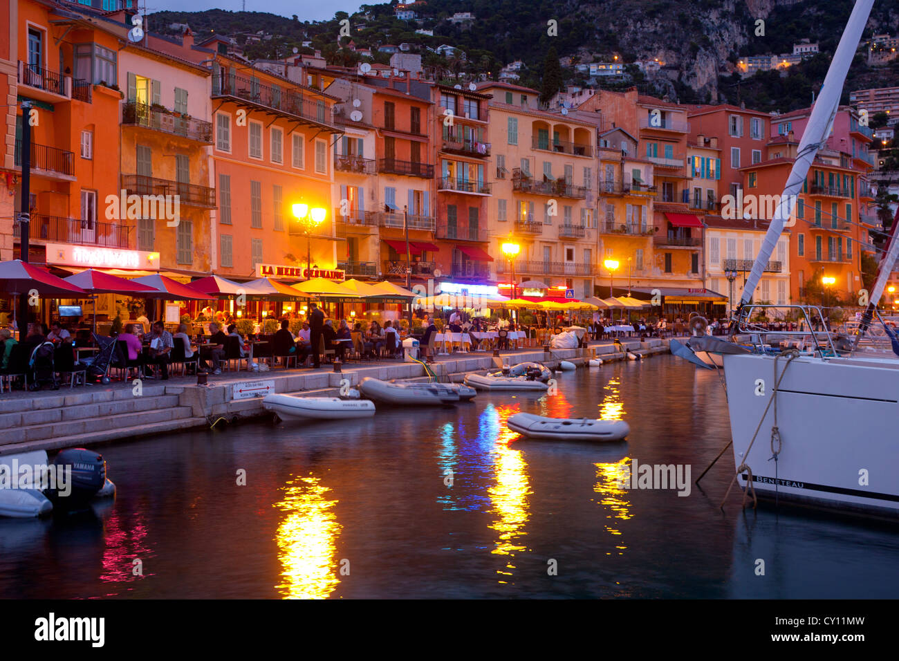 People dining at quayside restaurants at twilight Villefranche-sur-Mer Côte d'Azur Alpes-Maritimes France Stock Photo