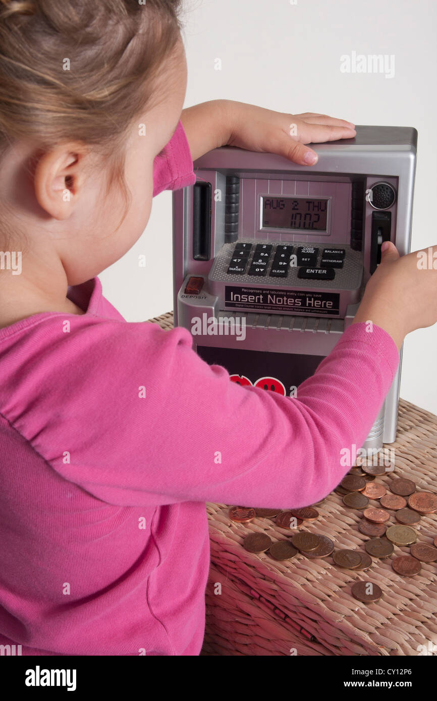 little girl playing on toy cash register Stock Photo