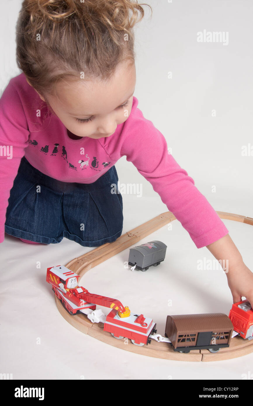 little girl playing with train set Stock Photo Alamy