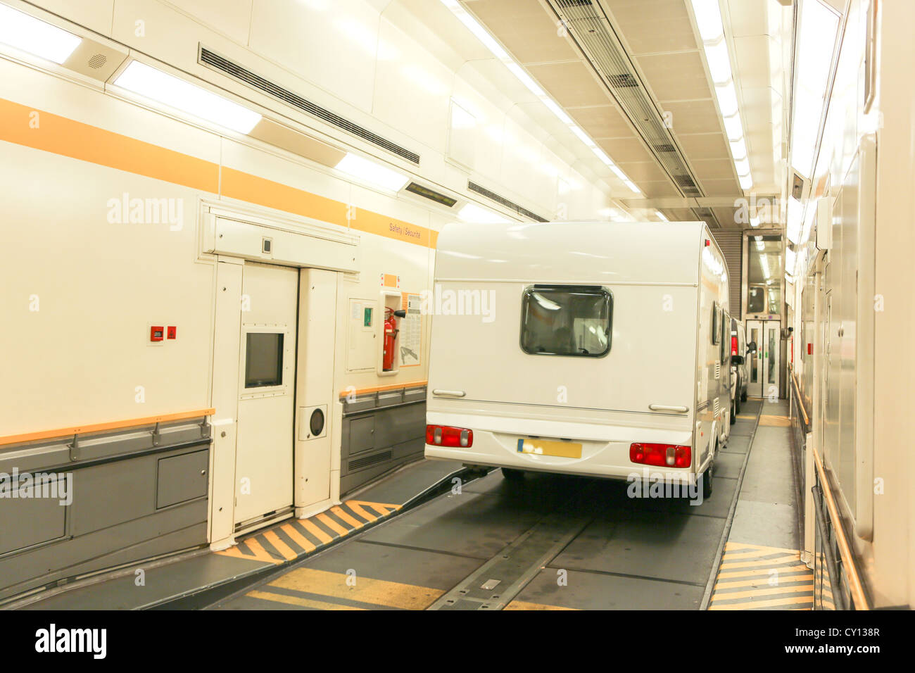 A car and trailer caravan inside a train carriage of a Eurotunnel Le Shuttle traveling through the Channel Tunnel. Stock Photo