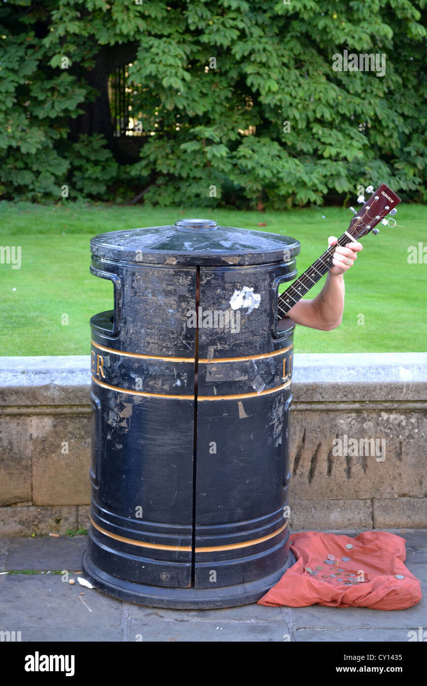 Busker/ Street Performer in rubbish bin singing and playing guitar, Trumpington St, Cambridge, England. Stock Photo