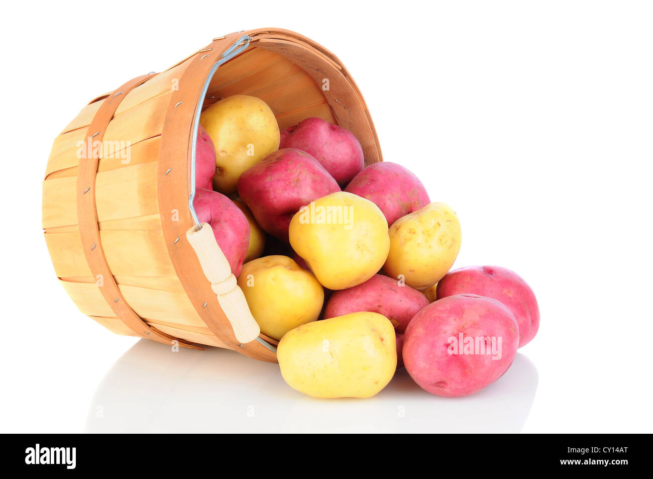 Red and Yukon Gold potatoes spilling from a basket onto a reflective