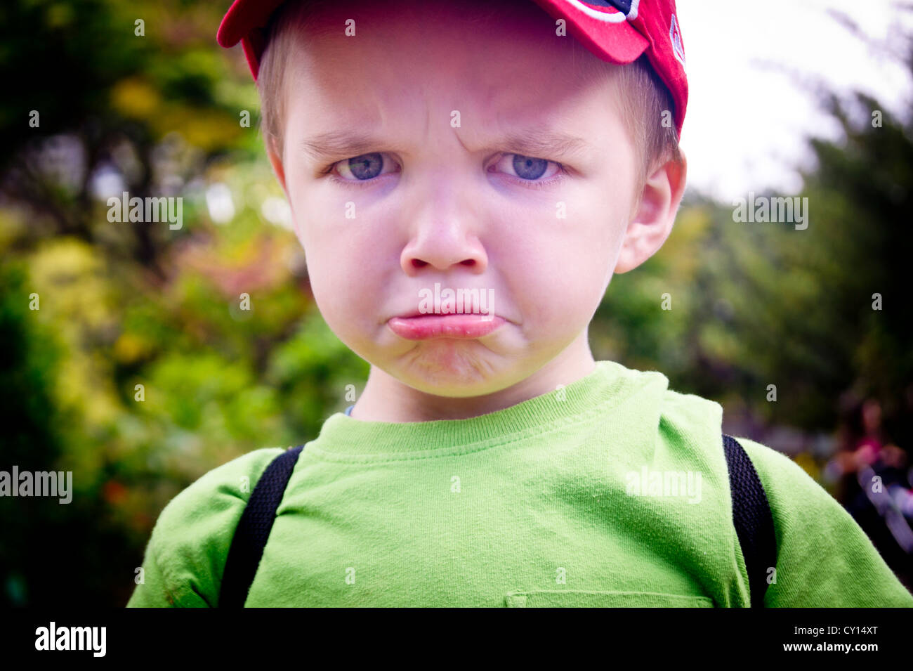 A five-year-old autistic boy frowns at camera. Stock Photo