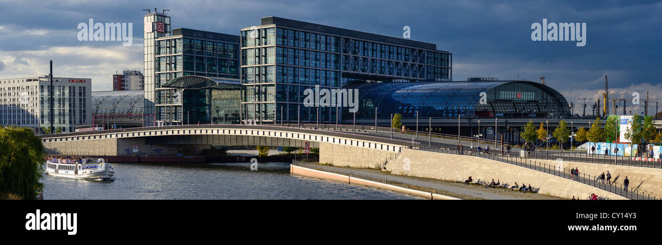 Berlin Central Station (HBF) panorama in dramatic light. Dark clouds in the background. Spree with tourist boat in in the front. Stock Photo