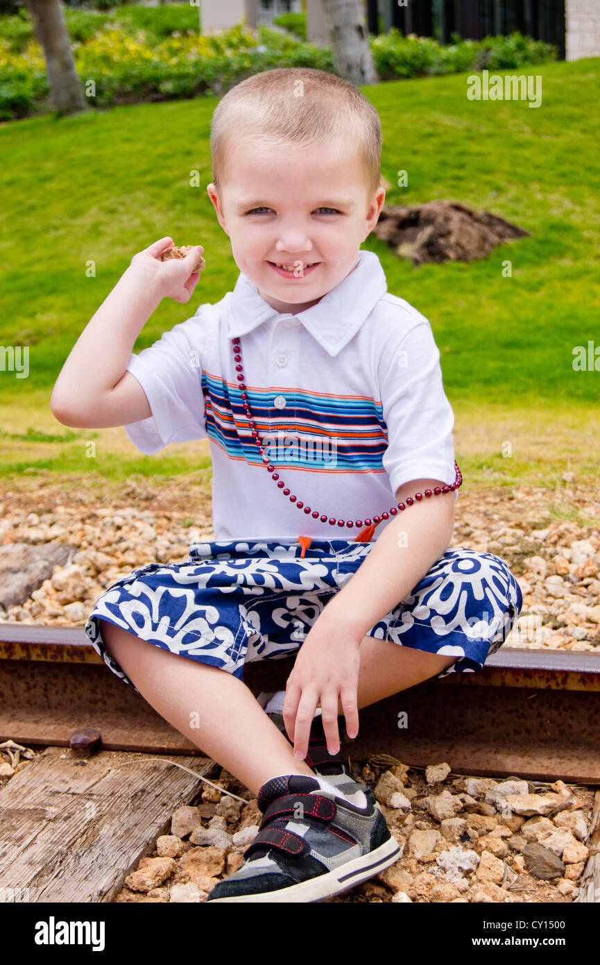 A young autistic boy is ready to throw a rock at the camera. Stock Photo