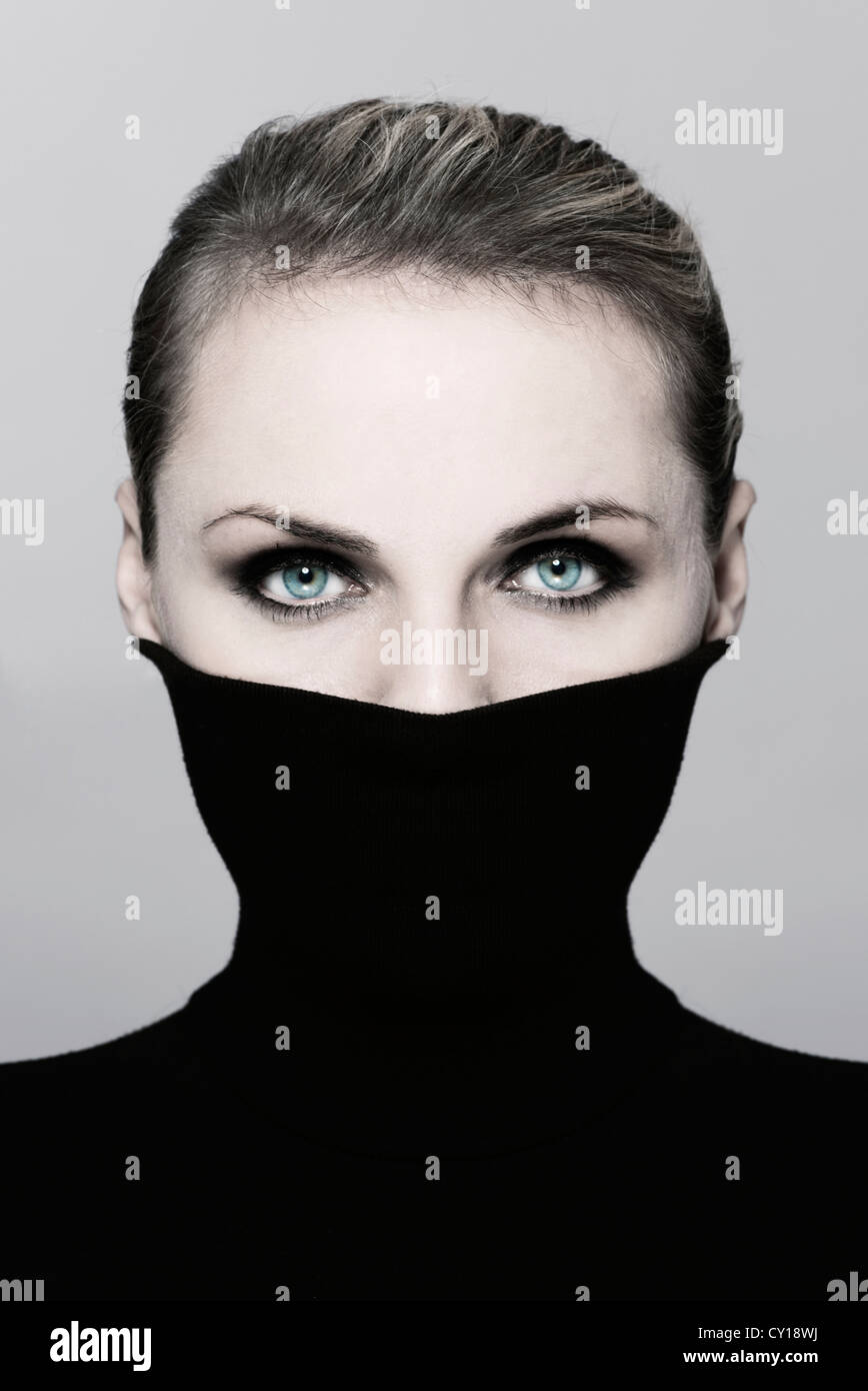 woman hiding her face with black polo neck jumper Stock Photo - Alamy