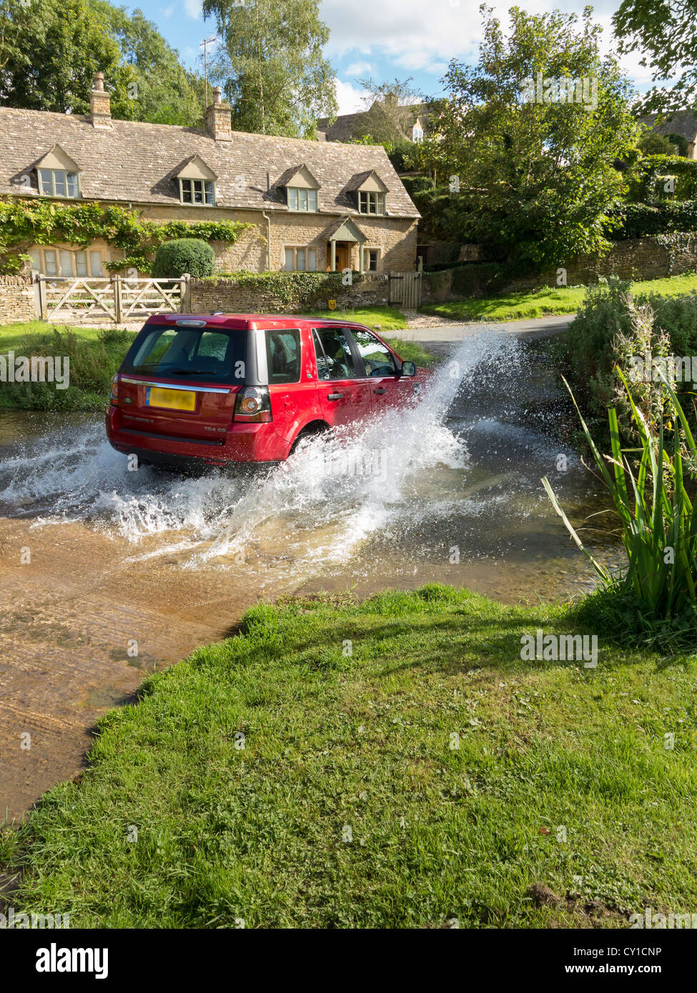 Land rover Freelander crossing a stream, Cotswolds, England Stock Photo