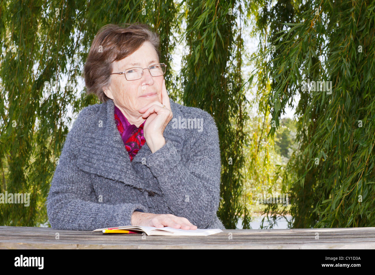 Senior woman reading outdoors. Stock Photo