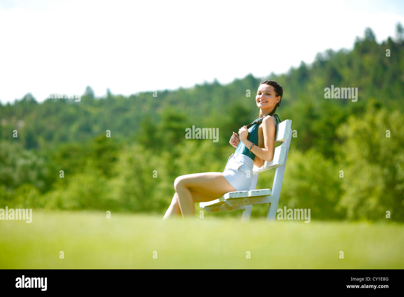 Young woman sitting on the bench in park Stock Photo - Alamy