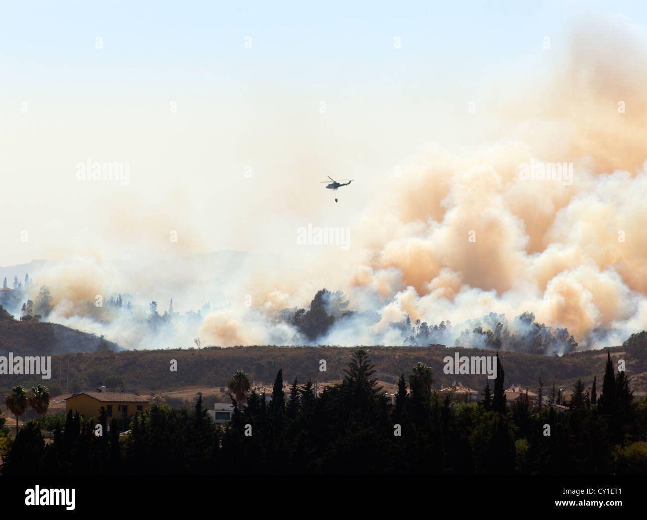 Rescue helicopter helping to extinguish wildfire. Mijas Costa, Malaga, Costa del Sol, Andalucia, Spain. Stock Photo