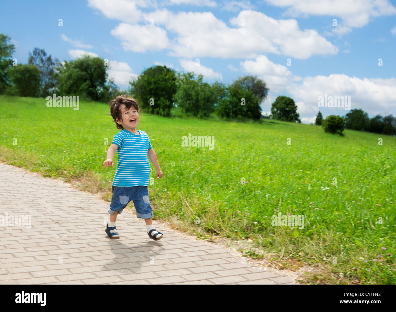 little boy running in park and laughing Stock Photo - Alamy