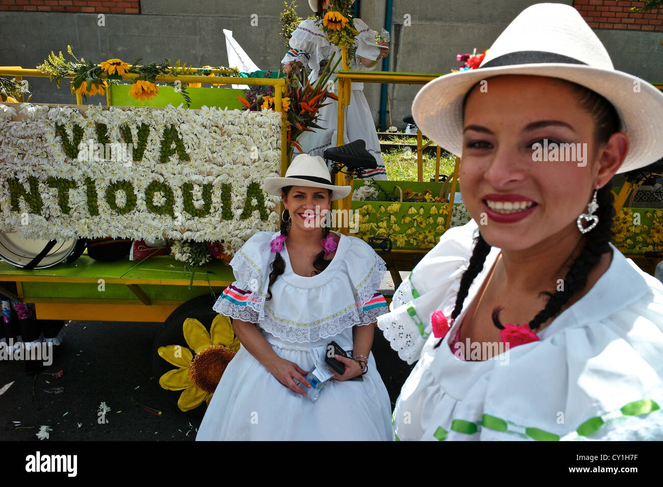 Two silleteras near a float enjoy the flower festival parade. Stock Photo