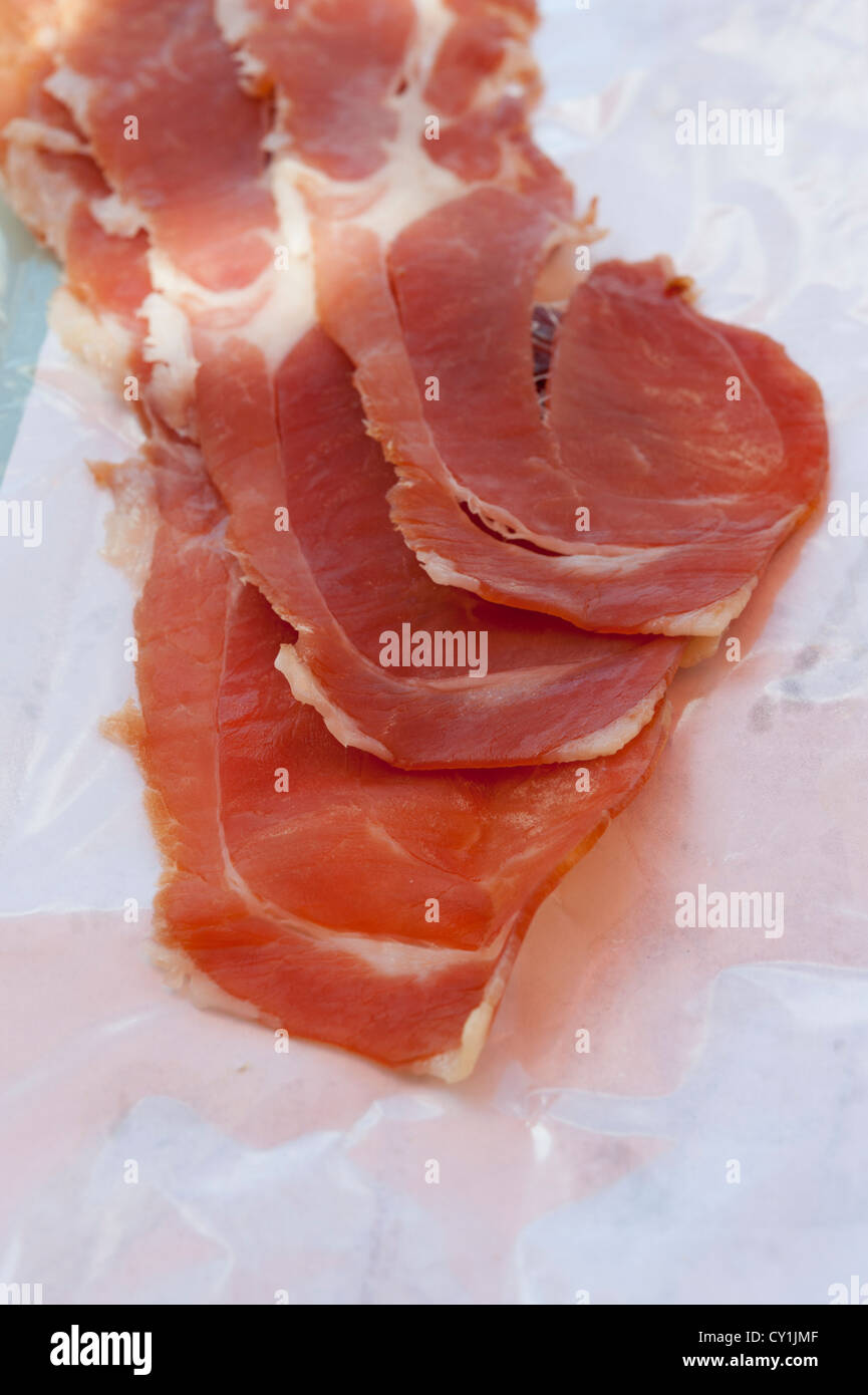 Slices of Iberico ham on waxed paper. This is Spanish cured ham from Jamonal de Mogan in Gran