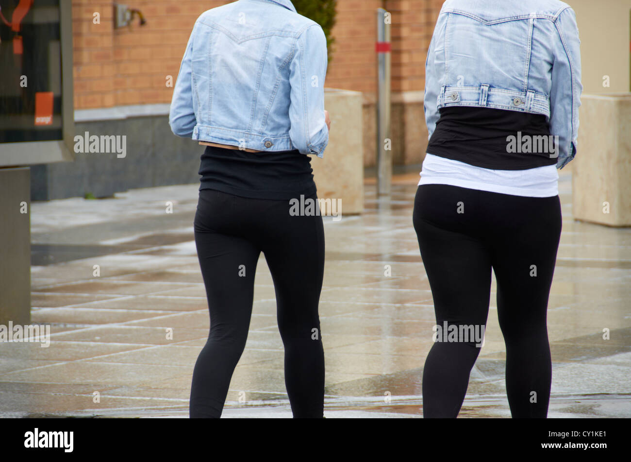 2 girls / women wearing black leggings & denim jackets Stock Photo