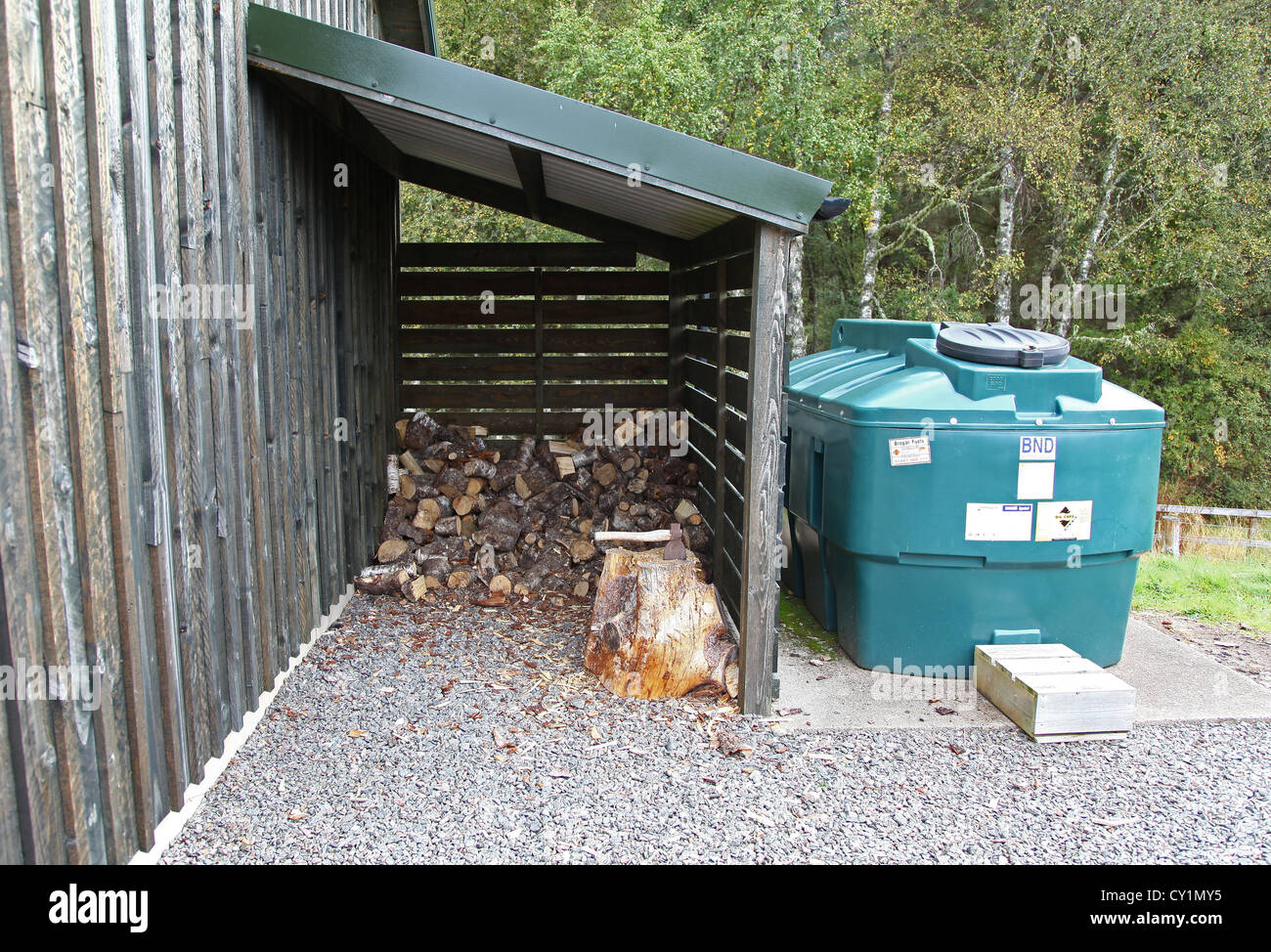 A log store and an oil tank a source of duel fuel at a remote building Stock Photo