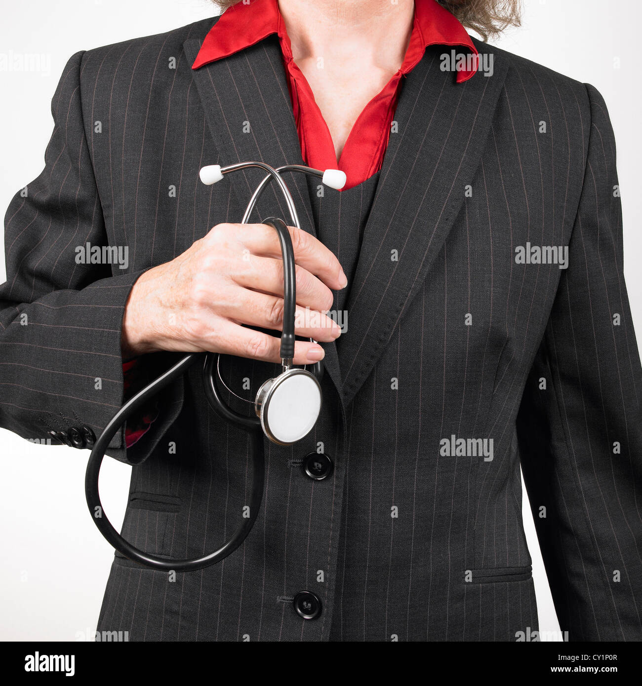 Woman GP wearing pinstripe suit holding stethoscope Stock Photo
