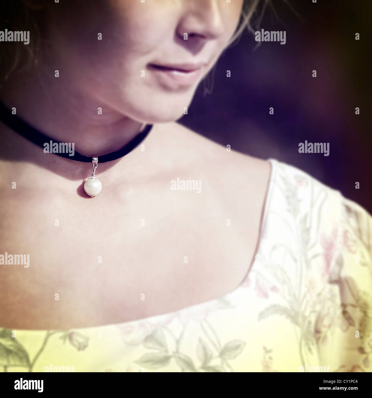 close-up of a woman in a flora dress with a pearl necklace Stock Photo