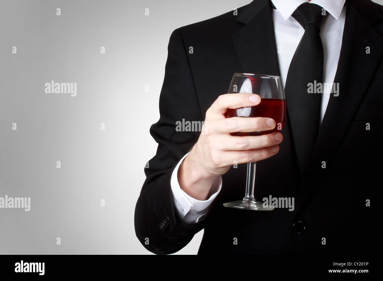 Elegant young man holding a glass of red wine Stock Photo - Alamy
